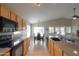 This kitchen flows into the dining area, featuring wood cabinets, stone countertops and black appliances at 2477 E Valencia Dr, Casa Grande, AZ 85194