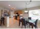 Open concept kitchen and dining area with stainless steel appliances, wood cabinets, and backyard views at 2477 E Valencia Dr, Casa Grande, AZ 85194