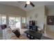 Comfortable living room with a ceiling fan, a large window overlooking backyard, and a sliding glass door at 2477 E Valencia Dr, Casa Grande, AZ 85194