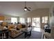 Spacious living room with vaulted ceiling, ceiling fan, tan leather sofa, and access to the backyard patio at 2477 E Valencia Dr, Casa Grande, AZ 85194