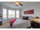 Serene main bedroom with a ceiling fan, large windows, and stylish decor at 2477 E Valencia Dr, Casa Grande, AZ 85194