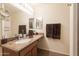 Bright bathroom featuring granite countertop, ample lighting, and a large wall mirror at 24816 N Good Pasture Ln, Florence, AZ 85132