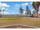 Backyard with patchy grass and a view of the golf course, with a stone-lined edge at 2535 E Saratoga St, Gilbert, AZ 85296