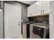 Laundry room with modern appliances, white cabinets, and a door to the rest of the house at 2535 E Saratoga St, Gilbert, AZ 85296