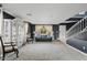 Bright living room with neutral carpet, dark accent walls, sofa, window, and a staircase at 2535 E Saratoga St, Gilbert, AZ 85296