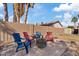 Outdoor patio area with four colorful chairs and a fire pit under a sunny sky at 2535 E Saratoga St, Gilbert, AZ 85296