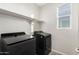 Laundry room featuring modern dark washer and dryer with a shelf and a window at 2622 E Monument Canyon Ave, Apache Junction, AZ 85119