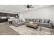 Open-concept living room featuring a gray sectional, a ceiling fan, and wood-look tile floors at 2622 E Monument Canyon Ave, Apache Junction, AZ 85119