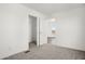 A carpeted bedroom featuring a view into an adjacent room, closet, and window views of the outdoors at 2735 S 357Th Dr, Tonopah, AZ 85354