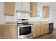 This is a stainless steel oven and light wood cabinets with dark knobs in a kitchen with light countertops at 2735 S 357Th Dr, Tonopah, AZ 85354