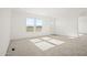 A bright, carpeted living room with fresh white paint, a large window, and a white front door at 2735 S 357Th Dr, Tonopah, AZ 85354