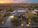 Stunning aerial view of desert home with a tile roof and circular drive surrounded by desert landscape and mountains at 27606 N 61St Pl, Scottsdale, AZ 85266