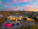 An aerial view of a home with a backyard pool and covered patio at dusk at 27606 N 61St Pl, Scottsdale, AZ 85266