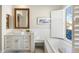 Bright bathroom featuring a vanity with sink, marble floors, and bathtub with natural light at 27606 N 61St Pl, Scottsdale, AZ 85266