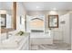 Bright bathroom featuring double sinks, marble floors, and bathtub with natural light at 27606 N 61St Pl, Scottsdale, AZ 85266