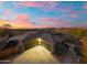 Sunset aerial view showcasing the house with its desert landscaping and attached three car garage at 27606 N 61St Pl, Scottsdale, AZ 85266