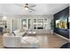 Bright living room featuring a plush sofa, decorative shutters, and natural light with wood-look flooring at 27606 N 61St Pl, Scottsdale, AZ 85266