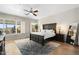 Bright main bedroom showcasing a king bed, wood floors, neutral walls and outdoor views at 27606 N 61St Pl, Scottsdale, AZ 85266