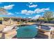 A backyard pool with tanning deck and patio furniture overlooks mature desert landscaping at 27606 N 61St Pl, Scottsdale, AZ 85266