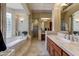 Well-lit bathroom featuring a soaking tub, tiled shower and dual vanities at 27701 N Lucero Dr, Rio Verde, AZ 85263