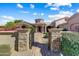 Stunning gated entrance with stone pillars, walkway, and lush landscaping leads to the front door at 27701 N Lucero Dr, Rio Verde, AZ 85263