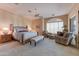 Spacious main bedroom with a sitting area, a ceiling fan, and a king-sized bed for ultimate relaxation at 27701 N Lucero Dr, Rio Verde, AZ 85263