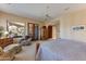 Bright main bedroom with a sitting area, outside views, a ceiling fan and elegant furnishings for relaxation at 27701 N Lucero Dr, Rio Verde, AZ 85263