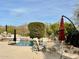 Outdoor dining area with table, chairs, and umbrellas next to a beautiful pool at 27701 N Lucero Dr, Rio Verde, AZ 85263