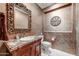 Chic powder room with a decorative mirror, marble countertop and custom paint for a luxurious feel at 27701 N Lucero Dr, Rio Verde, AZ 85263