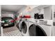 A well-organized garage featuring a front-loading washer and dryer next to a parked Integra at 30124 N Sunray Dr, San Tan Valley, AZ 85143