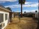 View of the backyard with a covered patio, a sparse lawn, and adjacent buildings at 3345 W Laurel Ln, Phoenix, AZ 85029