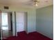 Bedroom with a closet, ceiling fan, and red carpet at 3345 W Laurel Ln, Phoenix, AZ 85029