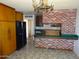 An eat-in kitchen featuring wood cabinets, brick accents, and a unique tile floor at 3345 W Laurel Ln, Phoenix, AZ 85029