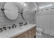 Bright bathroom with a dual sink vanity with a white countertop, wood-look tile, and modern light fixtures at 3459 E Mockingbird Dr, Gilbert, AZ 85234