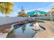 An in-ground pool offers a private oasis, complete with a rock feature, tanning ledge, and umbrella stands at 3459 E Mockingbird Dr, Gilbert, AZ 85234