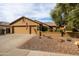 Charming home showcasing desert landscaping, a spacious three-car garage, and a welcoming facade with a decorative American flag at 3648 N 162Nd Ave, Goodyear, AZ 85395