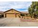 Traditional home with a three-car garage, desert-style landscaping, and an American flag displayed, radiating curb appeal at 3648 N 162Nd Ave, Goodyear, AZ 85395