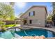 A backyard with a covered patio, lush lawn, and a beautiful swimming pool at 3708 E Bruce Ave, Gilbert, AZ 85234