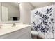 Bright bathroom features a stylish vanity and shower with modern leaf-patterned curtain at 3708 E Bruce Ave, Gilbert, AZ 85234