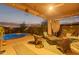 Inviting backyard patio featuring a sparkling pool, cozy seating, and decorative ambient lighting at 3767 W Desert Creek Ln, Phoenix, AZ 85086