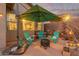 Backyard patio featuring bright Adirondack chairs under a large umbrella and an inviting firepit at 3767 W Desert Creek Ln, Phoenix, AZ 85086