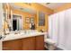 Bright bathroom with wood vanity, large mirror, and combined shower and tub featuring a shower curtain at 3767 W Desert Creek Ln, Phoenix, AZ 85086