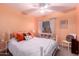 Vibrant bedroom with peach walls, white iron bed frame, and ample natural light at 3767 W Desert Creek Ln, Phoenix, AZ 85086