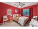 Eye-catching bedroom with red walls, ceiling fan, plush carpet, and bright window at 3767 W Desert Creek Ln, Phoenix, AZ 85086