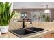 Granite countertops with a double sink and bronze colored plumbing fixture; snake plant in view at 3767 W Desert Creek Ln, Phoenix, AZ 85086