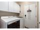 Well-equipped laundry room features white cabinets, modern washer and dryer, and a charming welcome sign at 3767 W Desert Creek Ln, Phoenix, AZ 85086