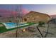 Beautiful backyard with a refreshing pool, green turf, string lights and desert landscaping at 41954 W Plata St, Maricopa, AZ 85138