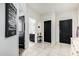 Bright hallway featuring tile floors, black doors, and neutral paint, exuding a modern and clean aesthetic at 41954 W Plata St, Maricopa, AZ 85138