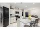 Open kitchen featuring white cabinets, granite countertops, stainless steel appliances and a breakfast bar at 41954 W Plata St, Maricopa, AZ 85138