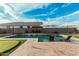 Beautiful backyard pool with travertine deck, spa, and putting green at 41954 W Plata St, Maricopa, AZ 85138